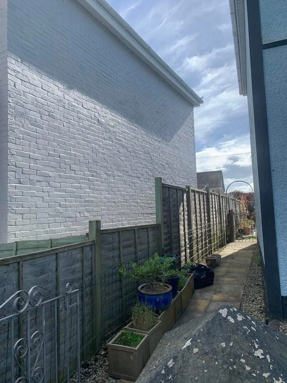 Freshly painted brick wall after preparation and masonry paint in Crediton