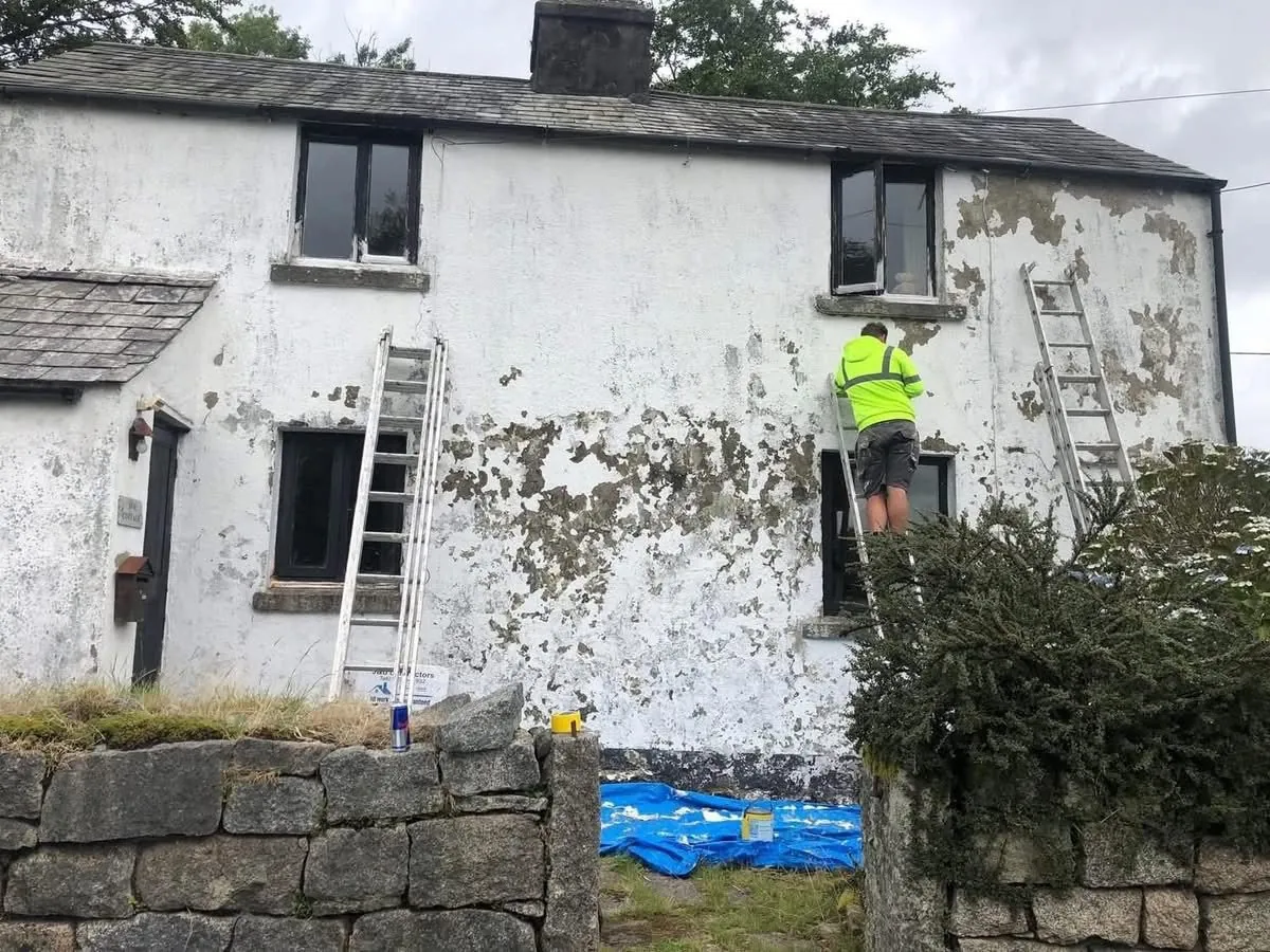 Cottage with blown, flaking render before repair in Crediton